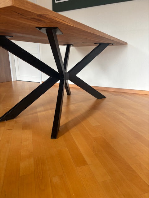 Esstisch aus Eiche mit Kreuzfuß von Wildwuchs-Möbel, präsentiert in natürlichem Holzfinish und zeitlosem Design.
