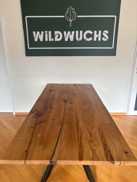 Esstisch aus Eiche mit Kreuzfuß von Wildwuchs-Möbel, naturbelassenes Design mit Holzmaserung.